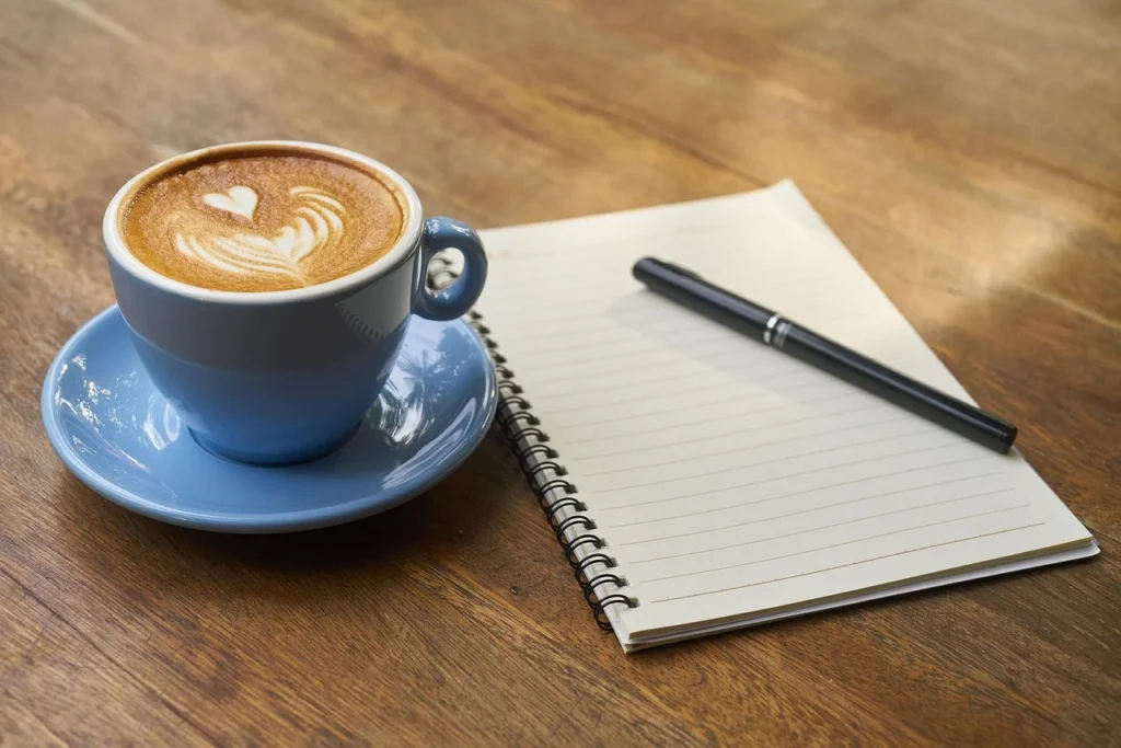 Adult sitting at a kitchen table with a notebook and a balanced meal, planning next steps for weight management
